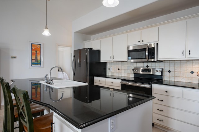 kitchen with white cabinets, a breakfast bar, an island with sink, and stainless steel appliances