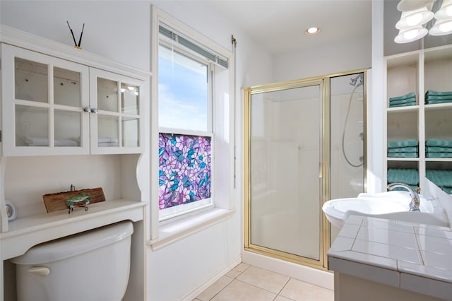 bathroom featuring tile patterned floors, sink, toilet, and walk in shower