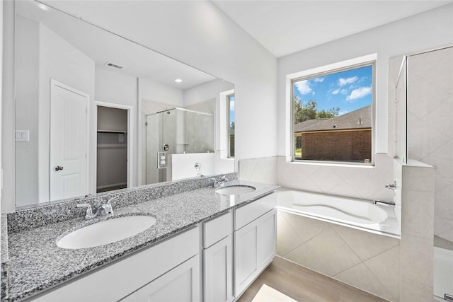 bathroom with shower with separate bathtub and vanity