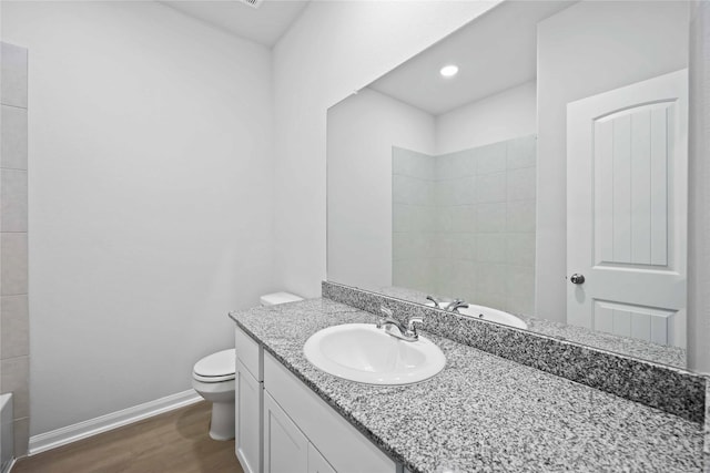 bathroom with hardwood / wood-style floors, vanity, and toilet