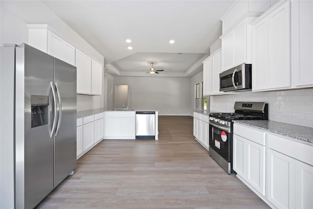 kitchen with white cabinets, stainless steel appliances, light hardwood / wood-style flooring, and ceiling fan