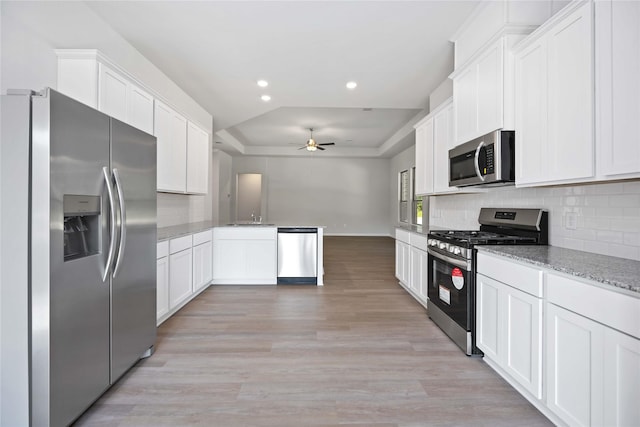 1485 Rd 66114, Dayton, TX 77535 - kitchen featuring stainless steel appliances, a ceiling fan, a tray ceiling, backsplash, and recessed lighting