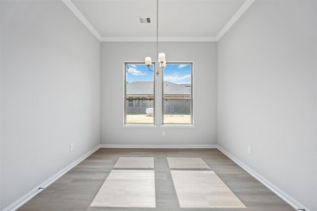 unfurnished dining area with crown molding, a chandelier, and wood-type flooring