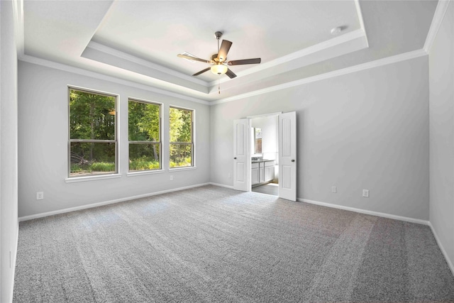 carpeted empty room with a raised ceiling, crown molding, and ceiling fan