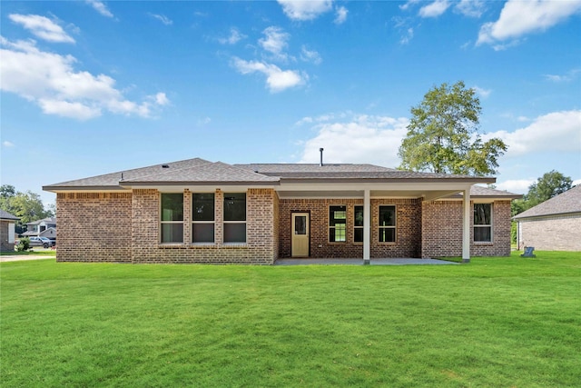 back of property with a yard and a patio