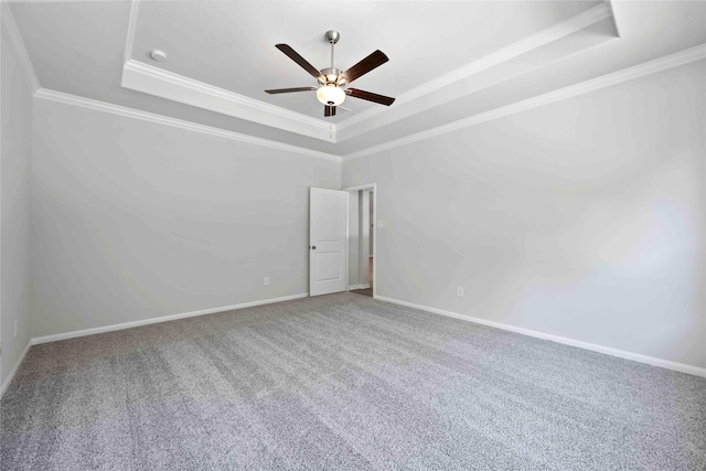 carpeted empty room featuring a tray ceiling, crown molding, and ceiling fan