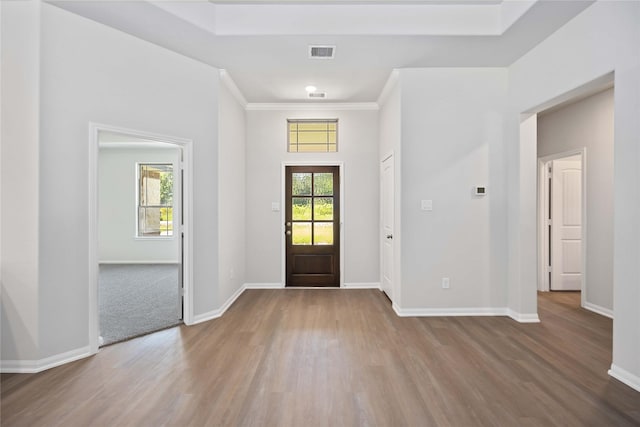 foyer entrance with crown molding and wood-type flooring