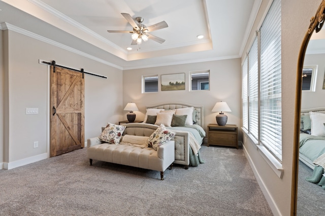 carpeted bedroom featuring a raised ceiling, a barn door, ceiling fan, and ornamental molding