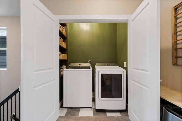 clothes washing area featuring light tile patterned floors and washer and clothes dryer