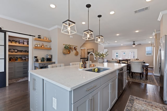 kitchen featuring ceiling fan, dark wood-type flooring, a kitchen island with sink, and stainless steel appliances