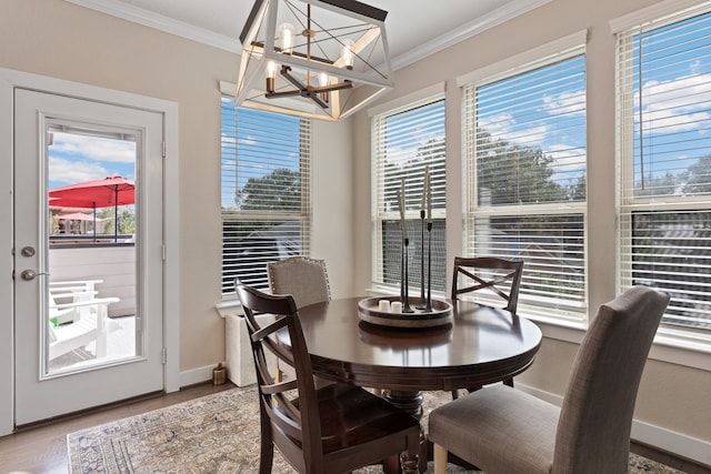 dining room featuring a chandelier, crown molding, and wood-type flooring