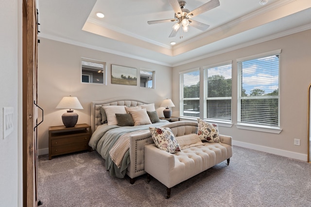 carpeted bedroom with ceiling fan, ornamental molding, and a tray ceiling