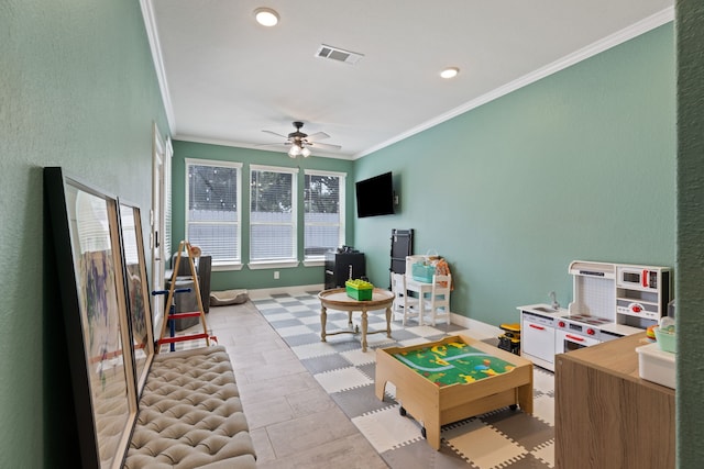 rec room featuring ceiling fan, light tile patterned floors, and ornamental molding