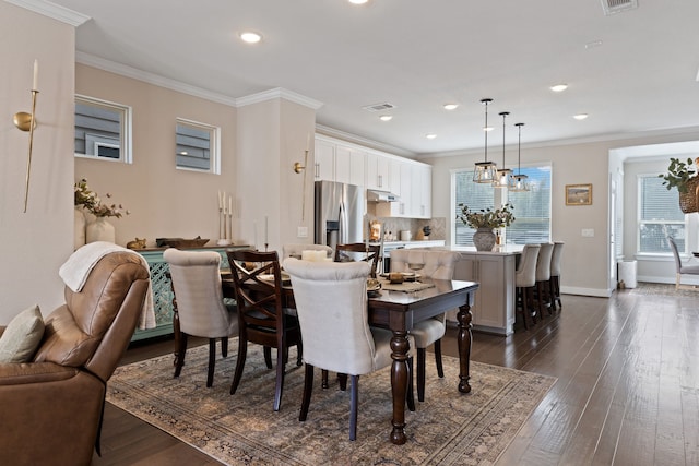 dining room featuring dark hardwood / wood-style flooring, an inviting chandelier, and ornamental molding