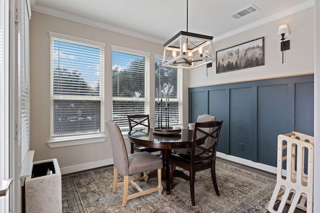 dining space with a chandelier and crown molding