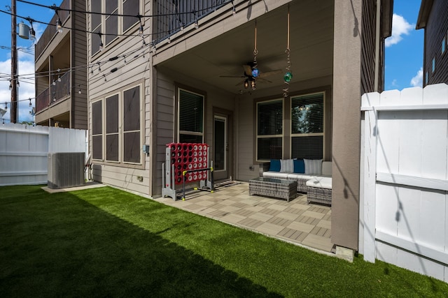 exterior space with outdoor lounge area, central air condition unit, ceiling fan, a yard, and a patio