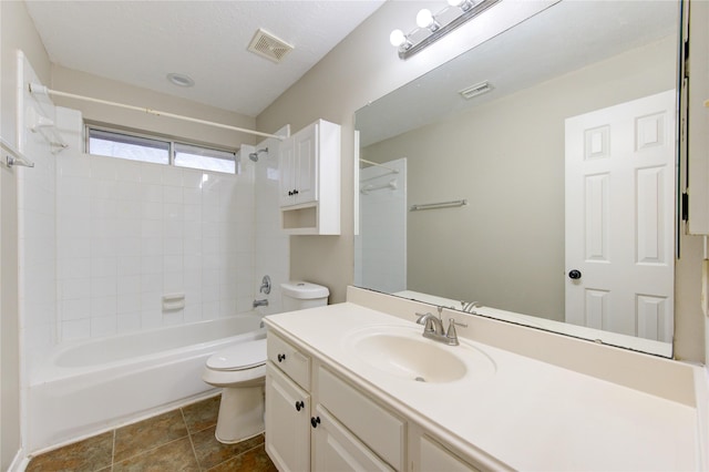 full bathroom with vanity, toilet, a textured ceiling, and tiled shower / bath combo