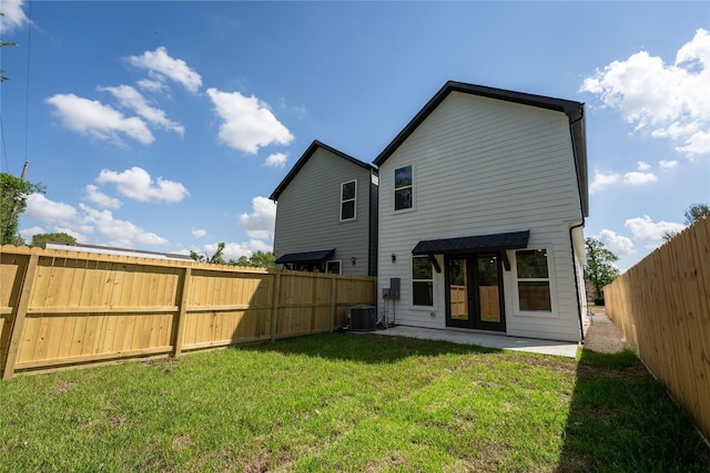 back of house with a patio area, central air condition unit, a yard, and french doors