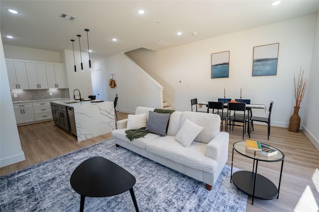 living room with sink and light wood-type flooring