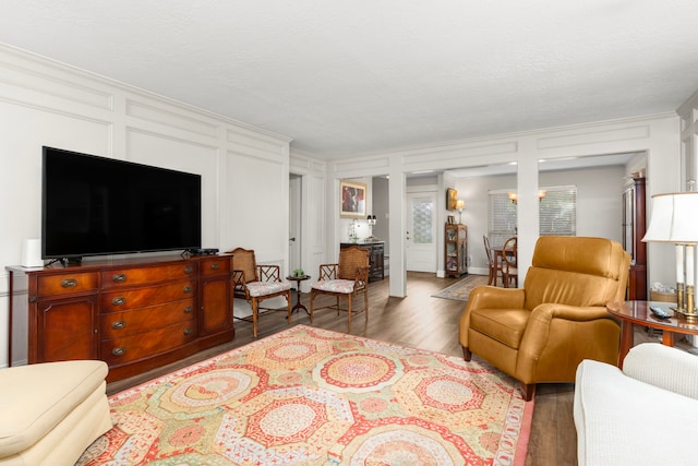 living room with wood-type flooring and ornamental molding