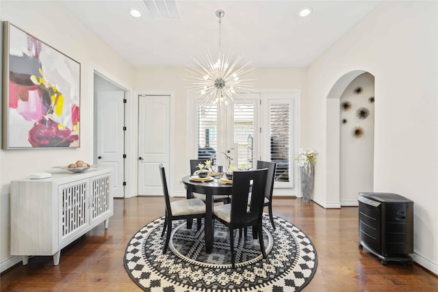 dining area with an inviting chandelier and dark wood-type flooring