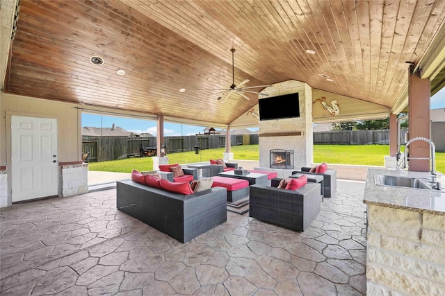 view of patio featuring an outdoor living space with a fireplace, ceiling fan, and sink