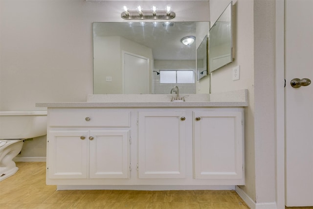 bathroom with toilet, vanity, and tile patterned floors