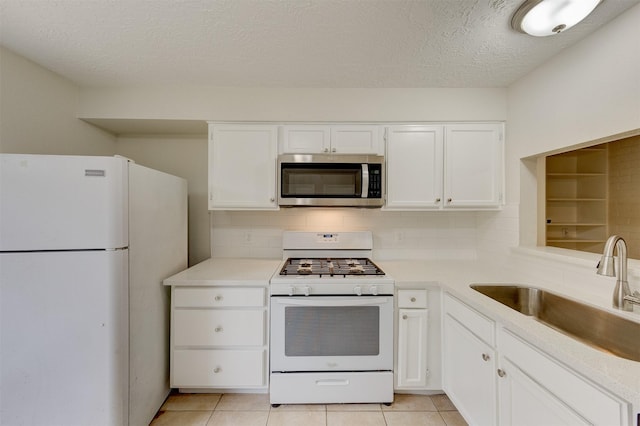 kitchen with a textured ceiling, white cabinetry, white appliances, and sink