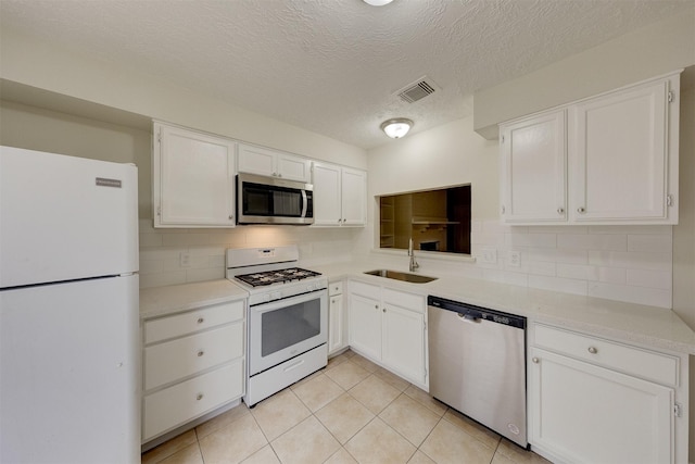 kitchen featuring backsplash, white cabinets, sink, a textured ceiling, and stainless steel appliances