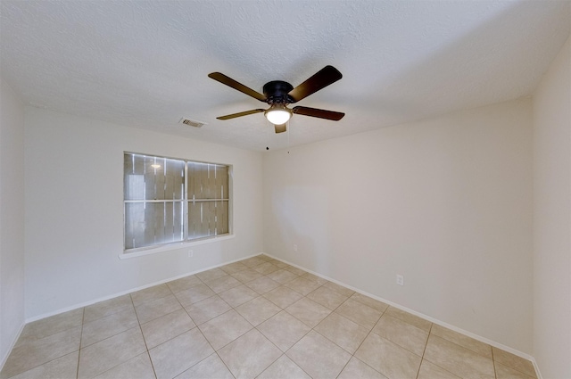 tiled spare room with a textured ceiling and ceiling fan