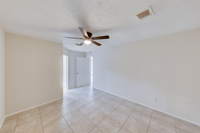 tiled spare room with a textured ceiling and ceiling fan