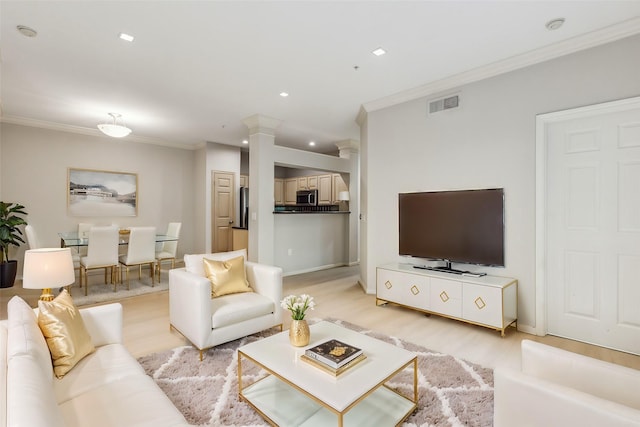 living room with crown molding and light hardwood / wood-style floors