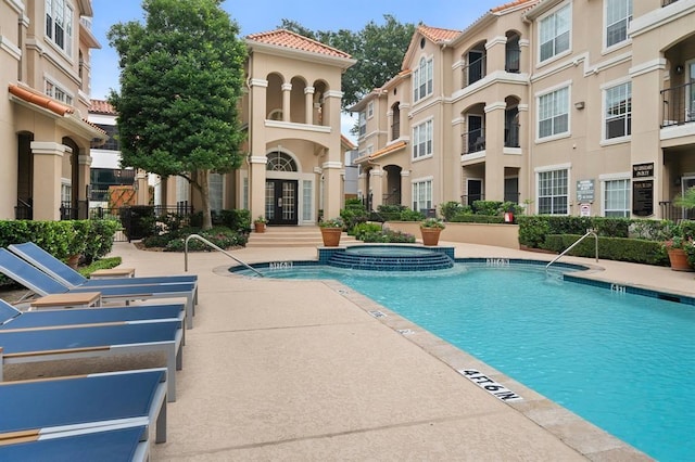 view of swimming pool with a patio and a hot tub