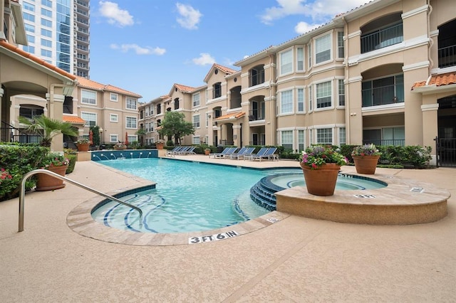 view of pool with pool water feature and a patio