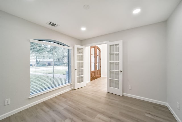 empty room with french doors and light hardwood / wood-style floors