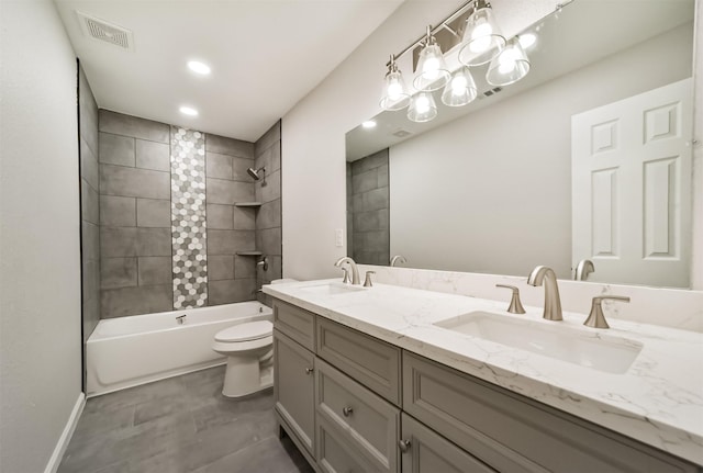 full bathroom featuring tiled shower / bath combo, toilet, and vanity