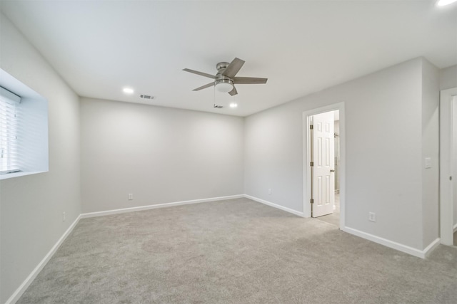 spare room featuring light carpet and ceiling fan