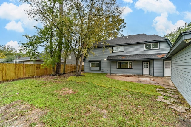 back of property with a patio area and a lawn