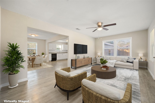 living room with light wood-type flooring and ceiling fan