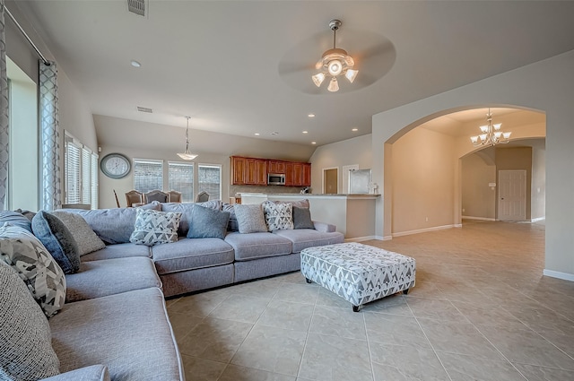 living room featuring light tile patterned floors and ceiling fan with notable chandelier