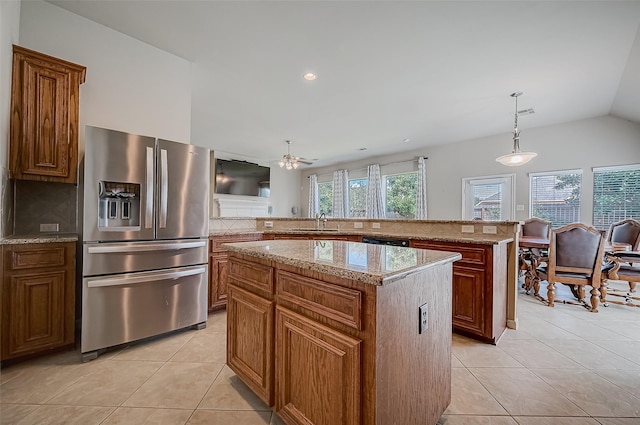 kitchen with ceiling fan, stainless steel appliances, a kitchen island, decorative light fixtures, and light tile patterned flooring