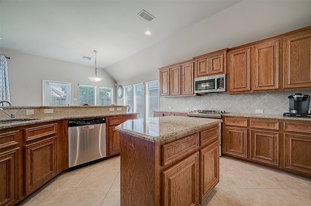 kitchen featuring stainless steel appliances, sink, pendant lighting, a center island, and lofted ceiling