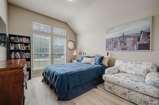 bedroom with vaulted ceiling and light hardwood / wood-style flooring