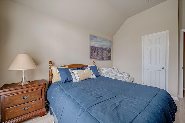 bedroom featuring light hardwood / wood-style floors and lofted ceiling