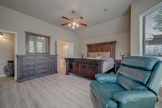 bedroom with light wood-type flooring, ensuite bath, vaulted ceiling, and ceiling fan