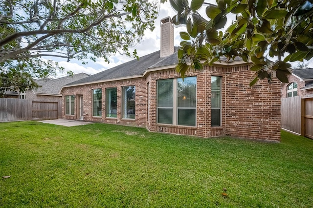 rear view of property with a yard and a patio