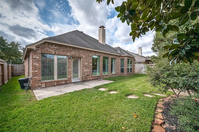 back of property with a lawn and a patio area