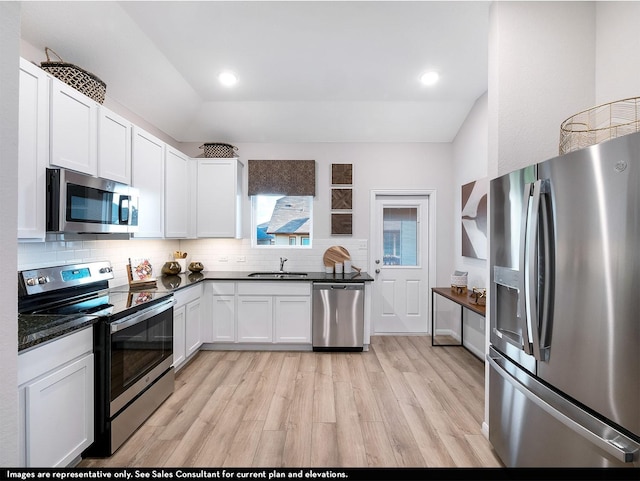 kitchen featuring sink, stainless steel appliances, tasteful backsplash, light hardwood / wood-style flooring, and white cabinets