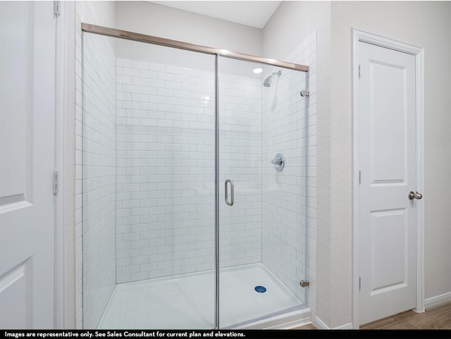 bathroom with hardwood / wood-style flooring and walk in shower