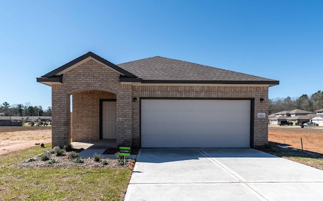 view of front of property featuring a shingled roof, concrete driveway, brick siding, and an attached garage